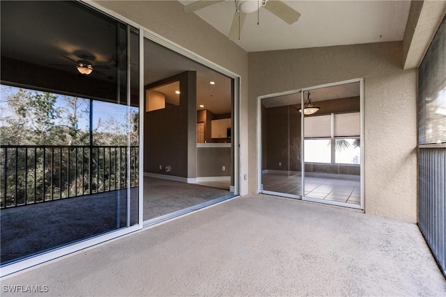 unfurnished sunroom with ceiling fan