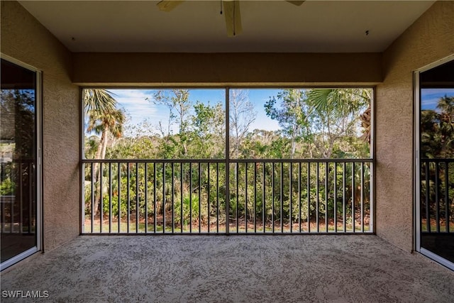 unfurnished sunroom featuring a wealth of natural light and ceiling fan