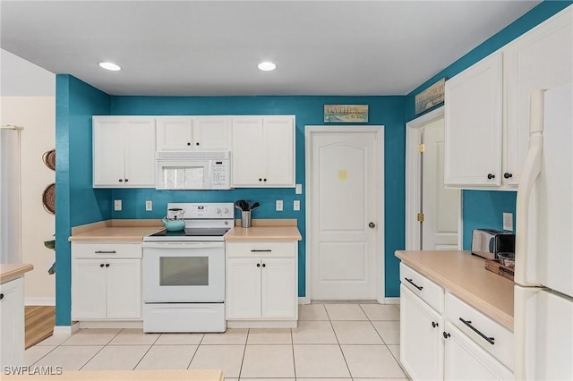 kitchen with light tile patterned floors, white cabinets, and white appliances