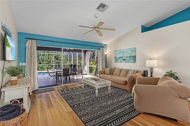 living room featuring hardwood / wood-style flooring, vaulted ceiling, and ceiling fan