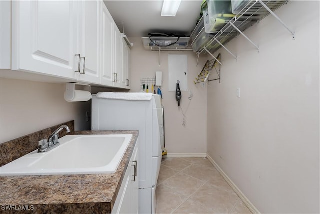 laundry area featuring cabinets, light tile patterned floors, sink, and washer / dryer