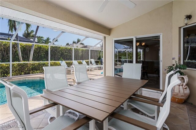 sunroom with ceiling fan, a pool, and lofted ceiling