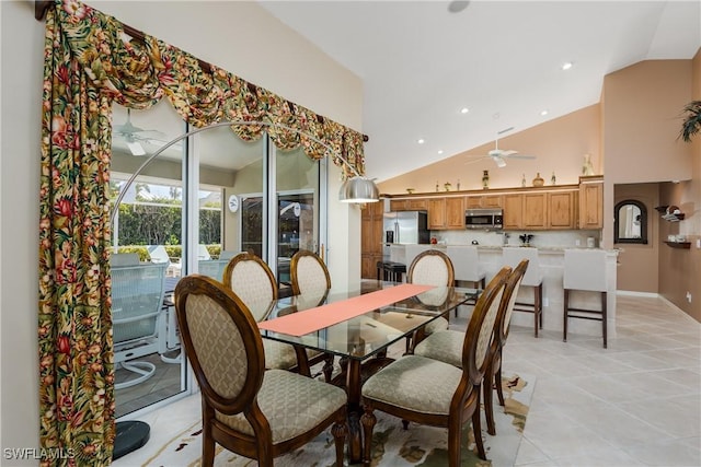 dining space featuring ceiling fan, light tile patterned floors, and vaulted ceiling