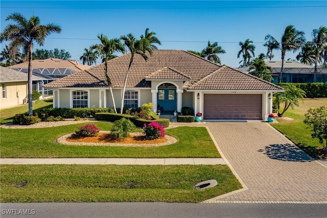 mediterranean / spanish-style home featuring a front yard and a garage