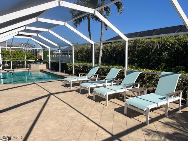 view of swimming pool featuring a patio area and a lanai