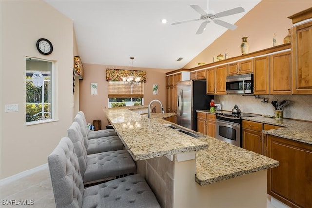 kitchen featuring a kitchen breakfast bar, a large island, pendant lighting, and stainless steel appliances