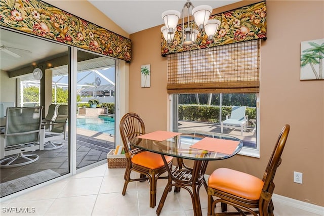 tiled dining area featuring vaulted ceiling and ceiling fan with notable chandelier