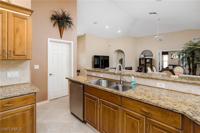 kitchen featuring dishwasher, light stone countertops, ceiling fan, and sink