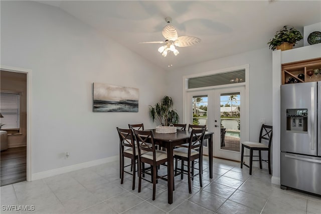 dining space with light tile patterned flooring, baseboards, vaulted ceiling, and french doors