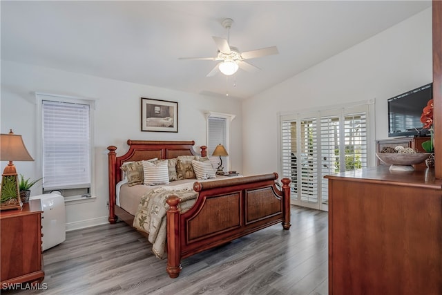 bedroom with access to exterior, lofted ceiling, ceiling fan, and wood finished floors