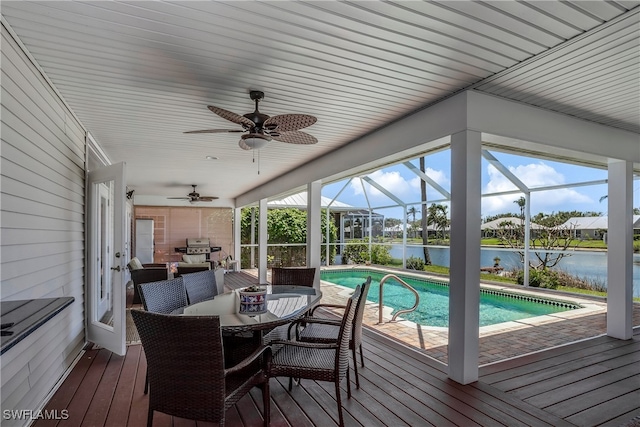 wooden terrace with a water view, outdoor lounge area, ceiling fan, and a lanai