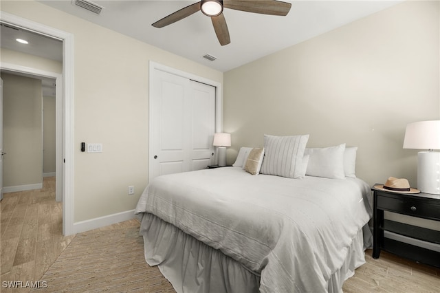 bedroom featuring ceiling fan, a closet, and light hardwood / wood-style flooring