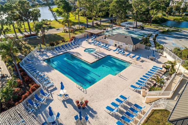 view of swimming pool with a water view and a patio