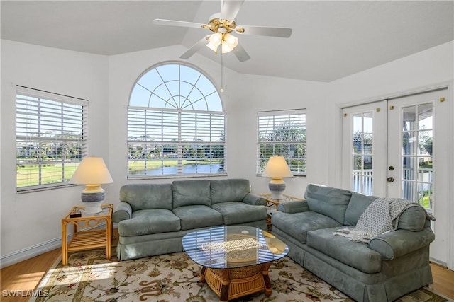 living room with hardwood / wood-style floors, ceiling fan, lofted ceiling, and french doors