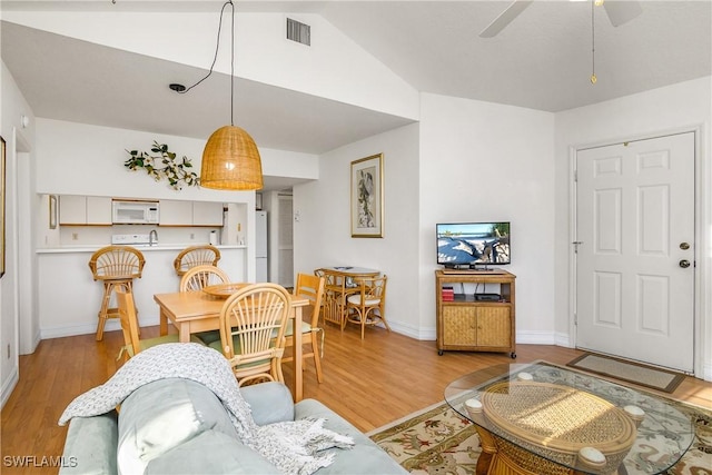 living room featuring light wood-type flooring, ceiling fan, and lofted ceiling