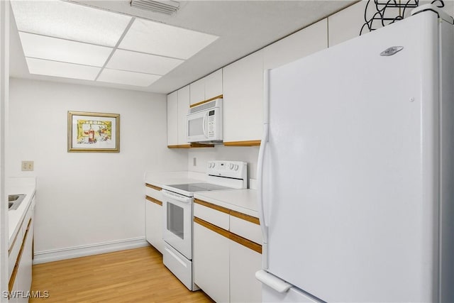 kitchen with white cabinets, white appliances, and light hardwood / wood-style flooring