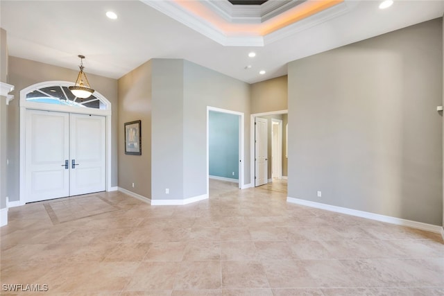 entryway featuring a raised ceiling and crown molding