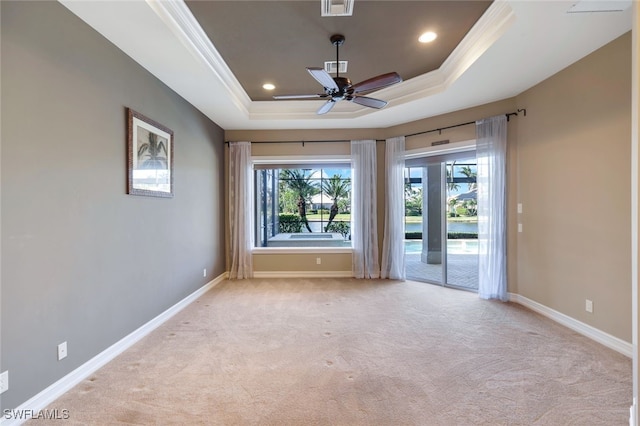 unfurnished room featuring ceiling fan, ornamental molding, a raised ceiling, and light colored carpet