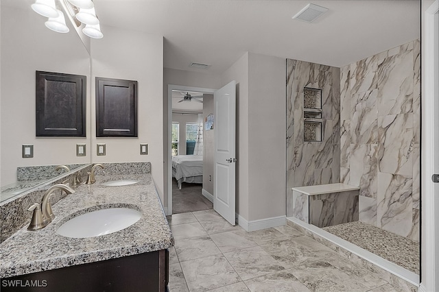 bathroom with tiled shower and vanity