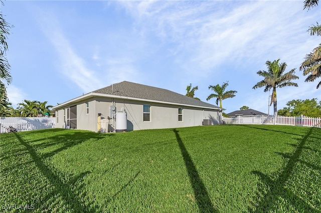 back of house featuring cooling unit and a yard