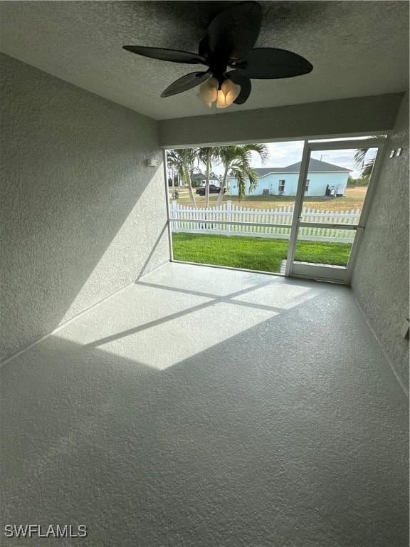 unfurnished sunroom featuring ceiling fan