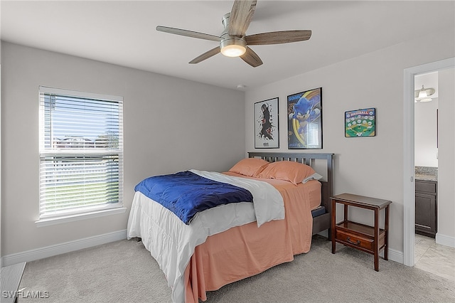 bedroom with ensuite bath, ceiling fan, and light colored carpet