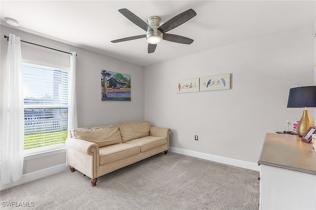 sitting room featuring ceiling fan, light colored carpet, and a wealth of natural light