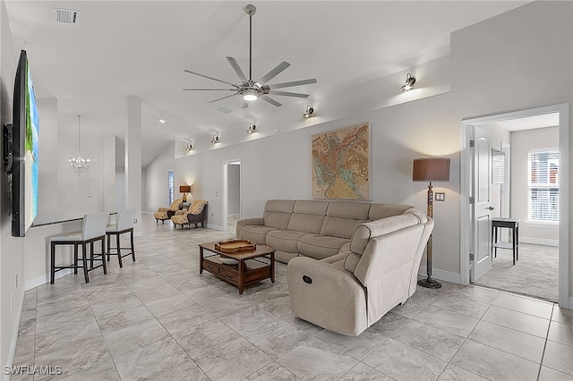 living room with ceiling fan with notable chandelier and vaulted ceiling