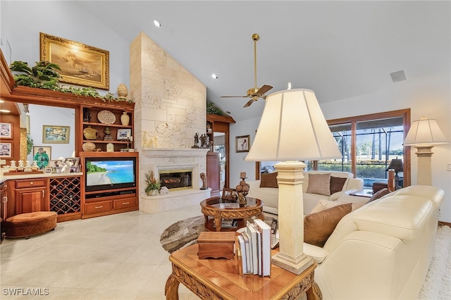 tiled living room with ceiling fan, a fireplace, and high vaulted ceiling