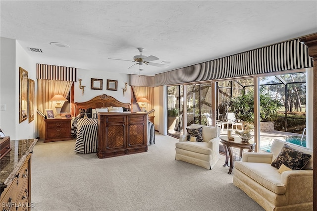 bedroom featuring access to exterior, a textured ceiling, light colored carpet, and ceiling fan