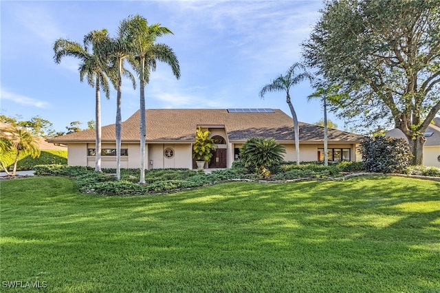 ranch-style house with solar panels and a front yard