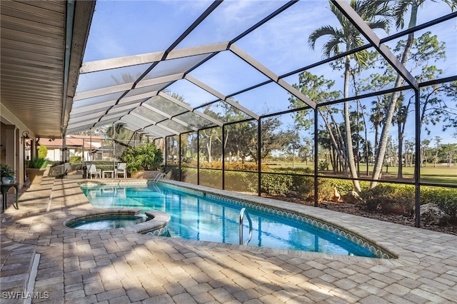 view of pool featuring glass enclosure, an in ground hot tub, and a patio