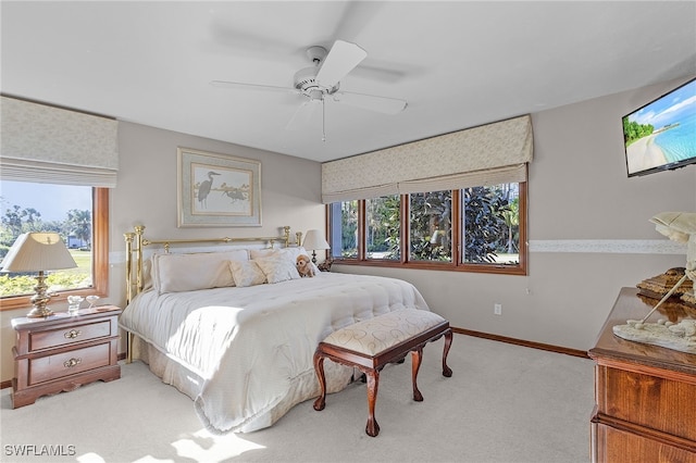 carpeted bedroom featuring ceiling fan and multiple windows