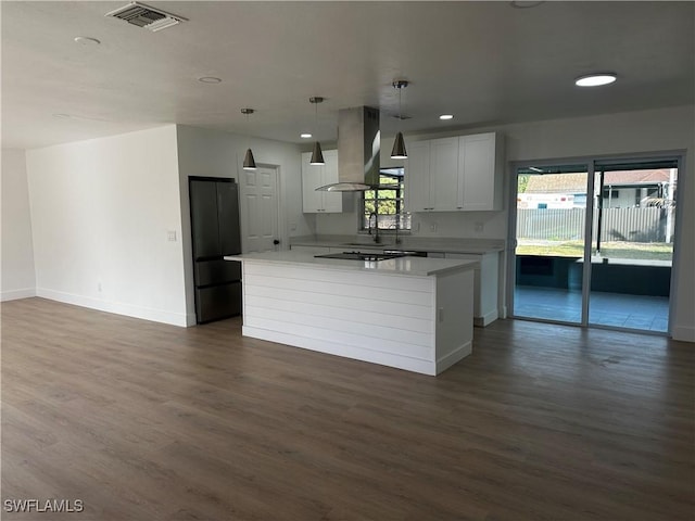 kitchen featuring a center island, dark hardwood / wood-style floors, island exhaust hood, decorative light fixtures, and white cabinets