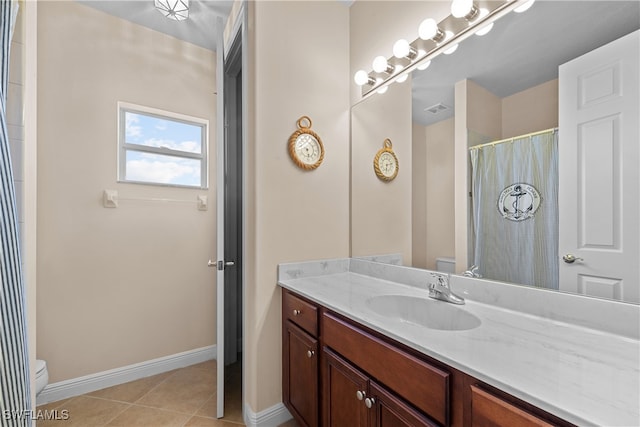 bathroom featuring tile patterned flooring, vanity, and toilet