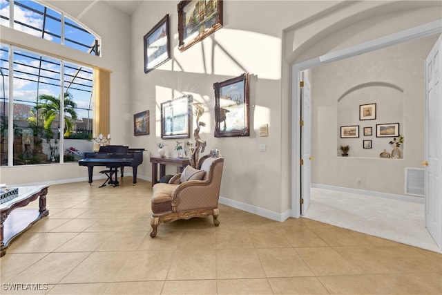 sitting room featuring light tile patterned flooring and a towering ceiling