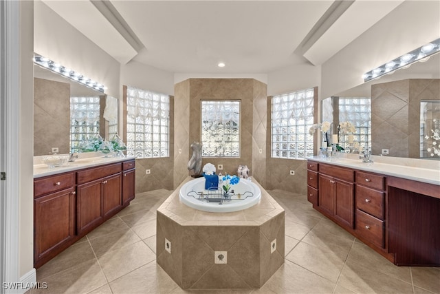 bathroom with a relaxing tiled tub, tile patterned floors, and tile walls