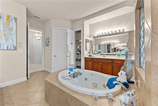 bathroom featuring tile patterned floors, vanity, a relaxing tiled tub, and an inviting chandelier