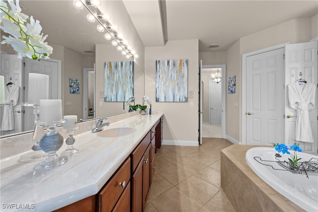 bathroom with tile patterned flooring, vanity, a chandelier, and tiled tub