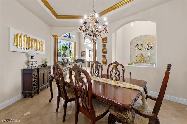 tiled dining space with a tray ceiling, ornate columns, crown molding, and a notable chandelier