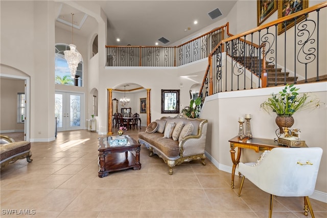 living room featuring french doors, a towering ceiling, light tile patterned flooring, and a notable chandelier