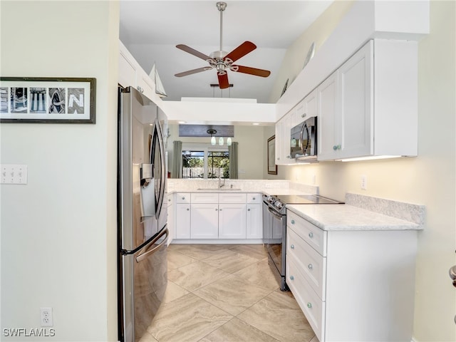 kitchen with appliances with stainless steel finishes, ceiling fan, sink, high vaulted ceiling, and white cabinets