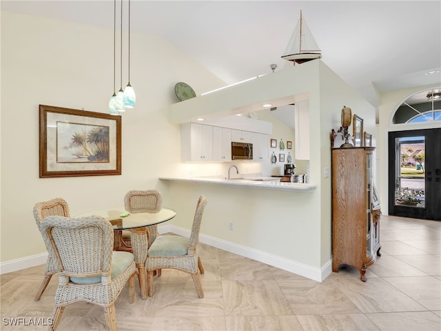 dining room featuring sink and vaulted ceiling