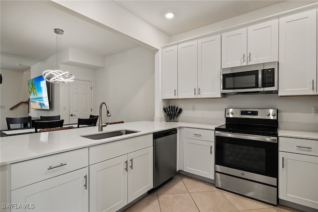 kitchen featuring pendant lighting, sink, kitchen peninsula, and stainless steel appliances