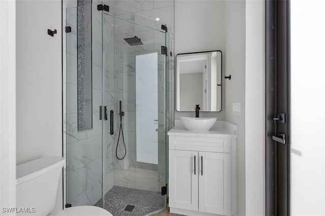 bathroom with vanity, toilet, and a shower with shower door