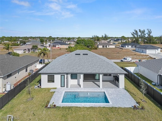 back of house featuring a yard, a fenced in pool, and a patio area