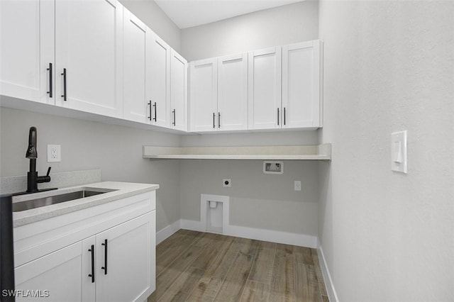 clothes washing area with sink, cabinets, washer hookup, electric dryer hookup, and hardwood / wood-style floors