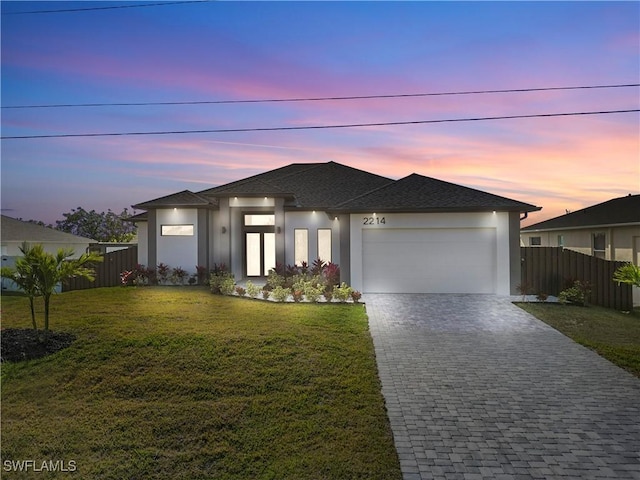 view of front of home with a yard and a garage