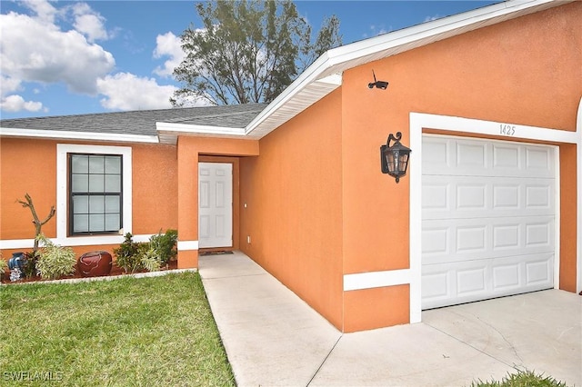 entrance to property with a lawn and a garage