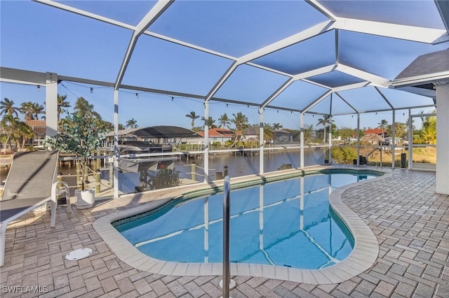 view of pool featuring glass enclosure, a water view, a patio, and a boat dock